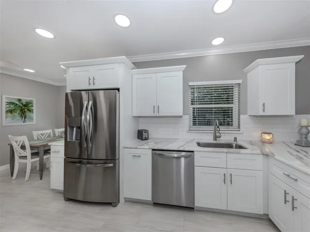 a dining room with furniture and kitchen view