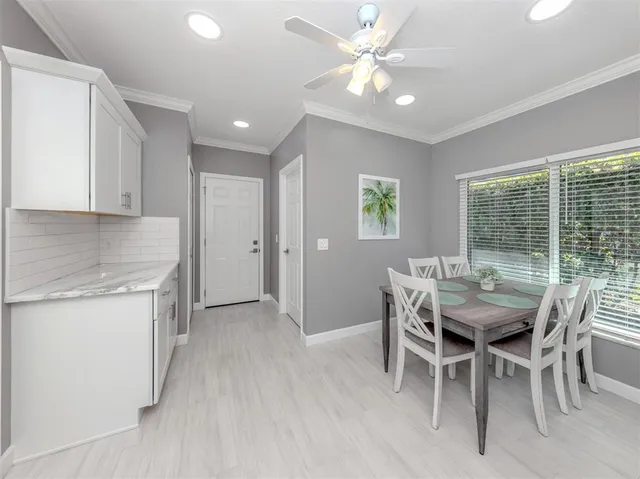 a kitchen with stainless steel appliances kitchen island granite countertop a table chairs sink and cabinets
