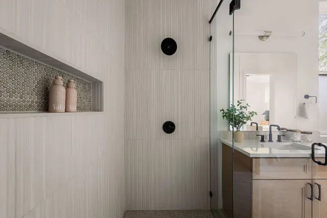 a bathroom with a sink a mirror a window and shower