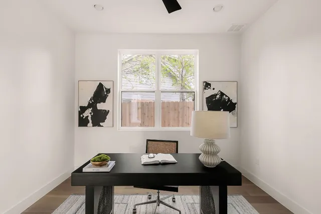 a view of a workspace with furniture and a window