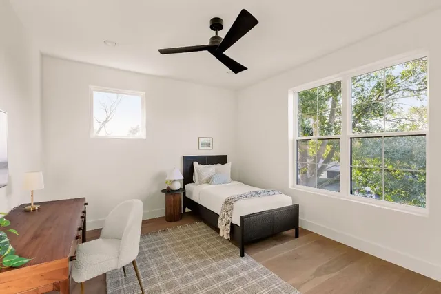 a bedroom with a bed a chair and a large window