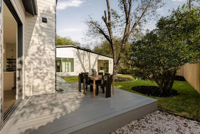 a view of a house with backyard and a trees