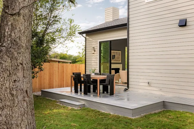 a view of a house with backyard and deck