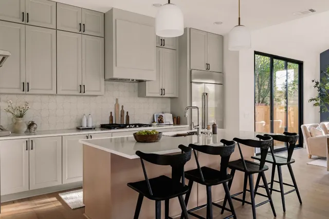 a kitchen with stainless steel appliances granite countertop a table chairs sink and cabinets