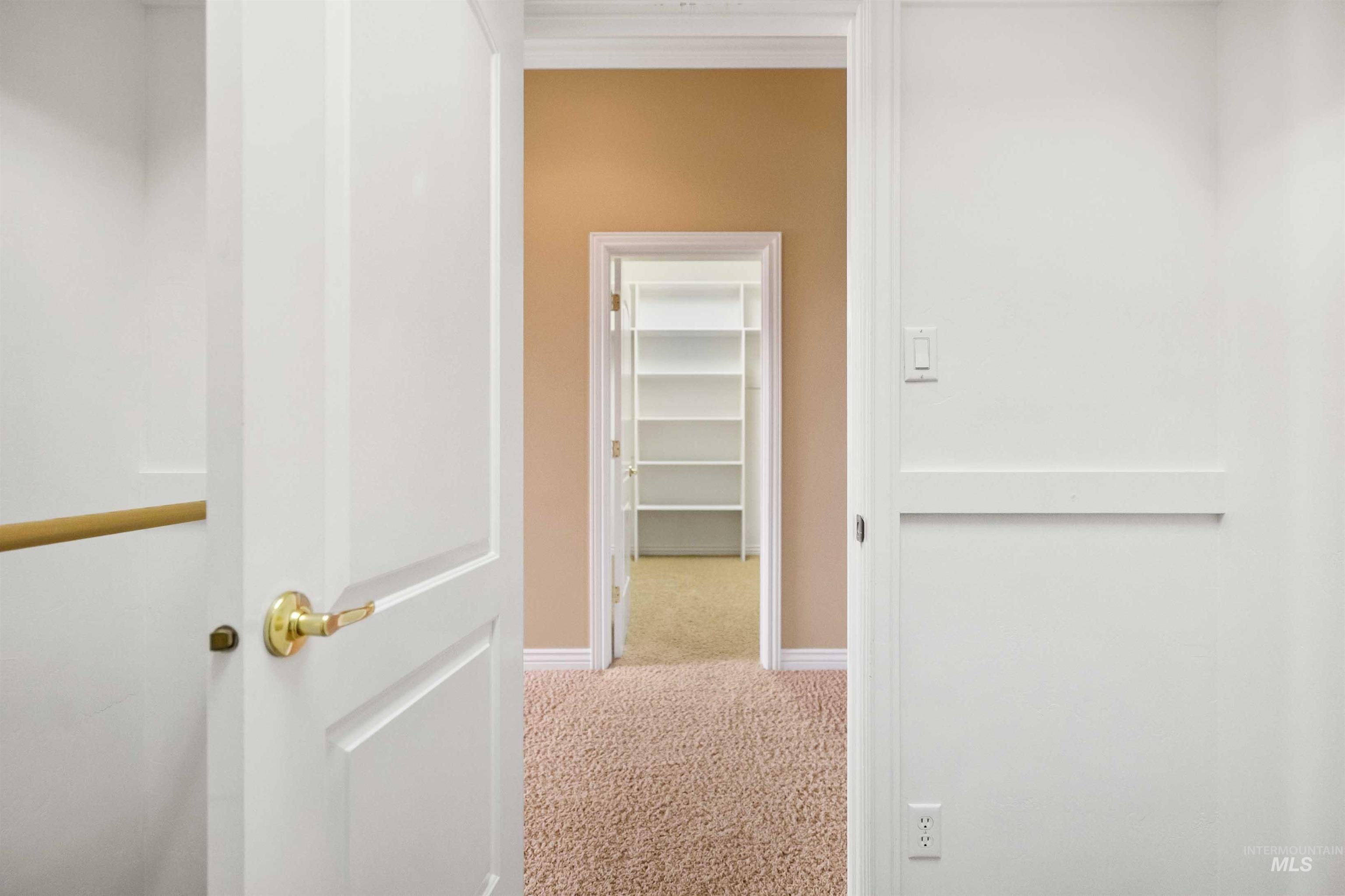 3404 Ridge Line Drive Kimberly, ID 83341 - Photo 22 of 50 Interior hallway with neutral carpeting leading to a walk-in closet featuring built-in shelving
