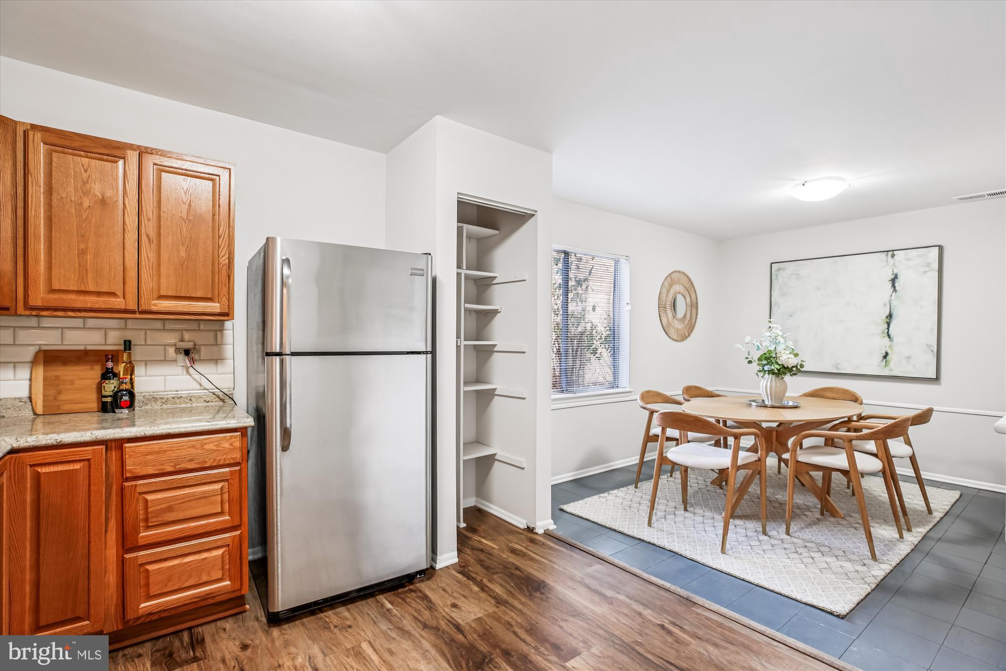 14410 Parkvale Road, Unit 2 Rockville, MD 20853 - Photo 11 of 37 a kitchen with stainless steel appliances granite countertop a refrigerator a stove a sink with dining table and chairs