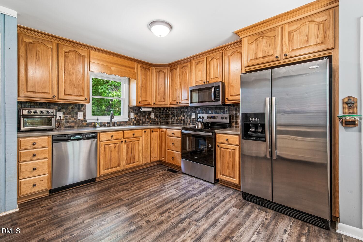 134 Longview Road Madison, NC 27025 - Photo 12 of 49 a kitchen with stainless steel appliances granite countertop a refrigerator a stove top oven a sink and dishwasher with wooden floor