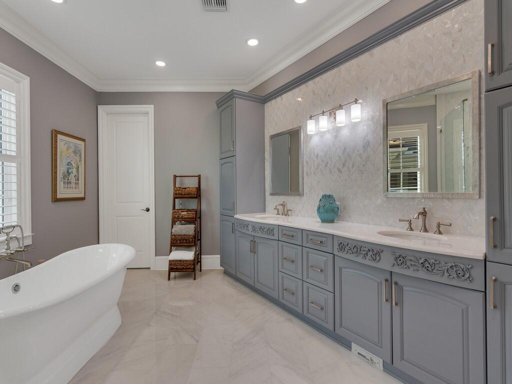 400 Oceanview Lane Vero Beach, FL 32963 - Photo 32 of 59 a spacious bathroom with a double vanity sink a large mirror and a bathtub