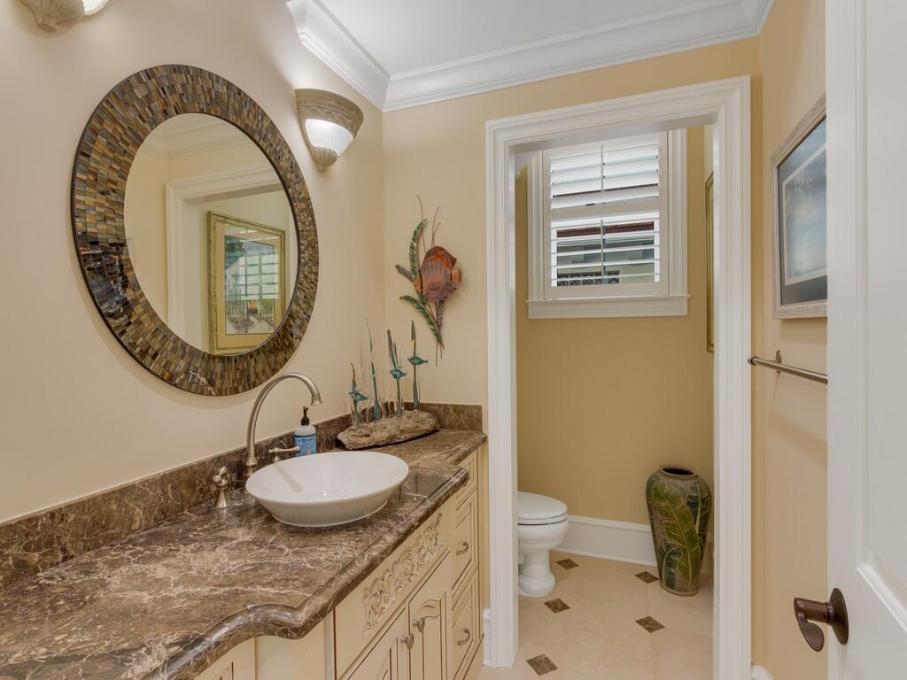 400 Oceanview Lane Vero Beach, FL 32963 - Photo 49 of 59 a bathroom with a granite countertop toilet a sink and a mirror