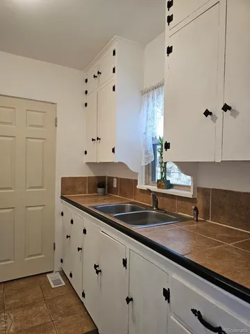 a kitchen with granite countertop white cabinets and white appliances