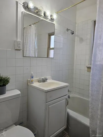 a bathroom with a sink toilet vanity and shower