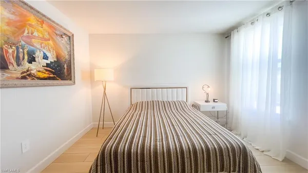 a bedroom with a bed and painting on the wall
