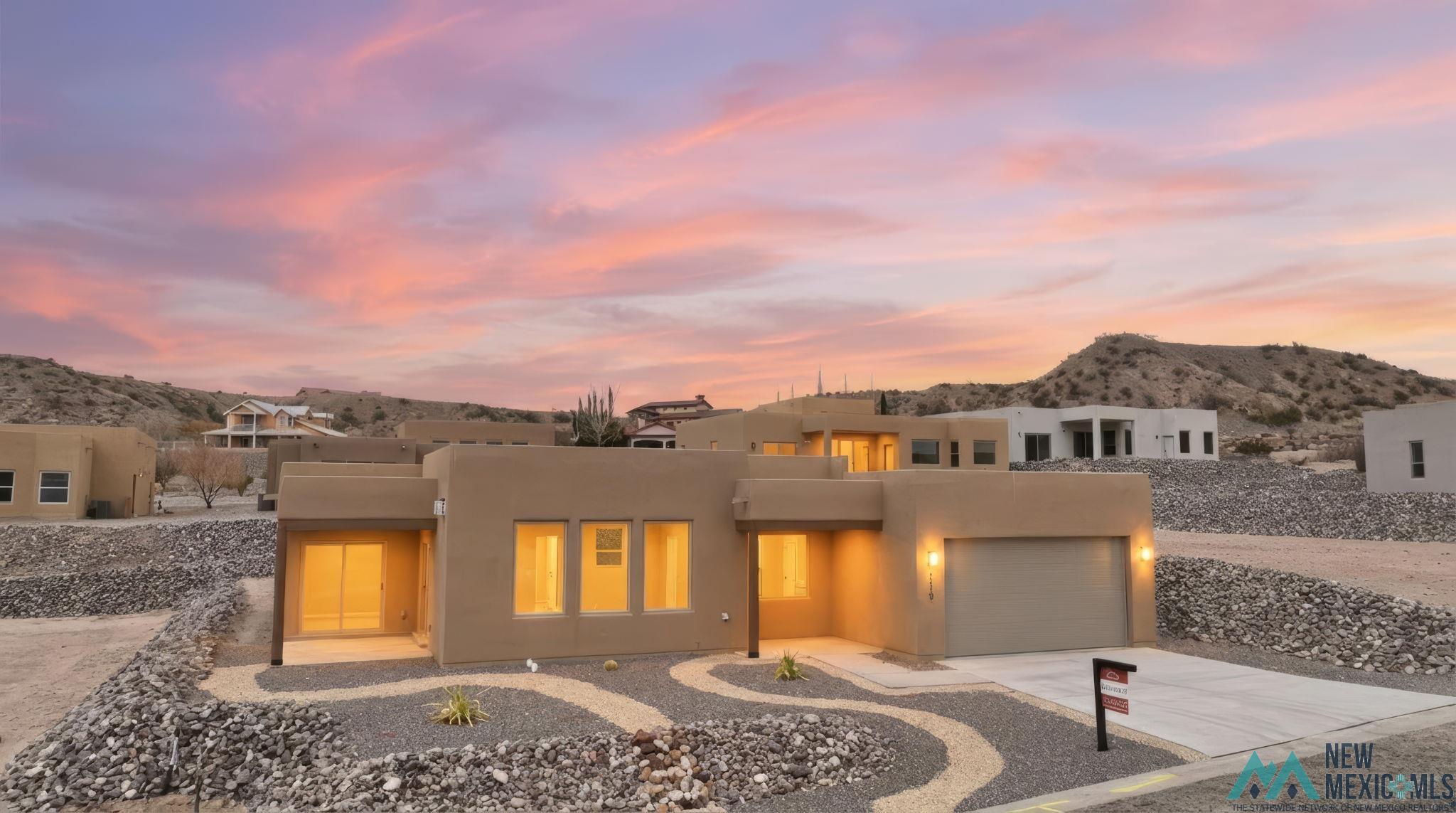 119 Mesa Grande Road Elephant Butte, NM 87935 - Photo 2 of 34 Southwest-style home featuring a mountain view, stucco siding, and driveway