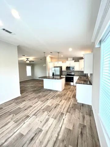 a view of kitchen and living room with wooden floor