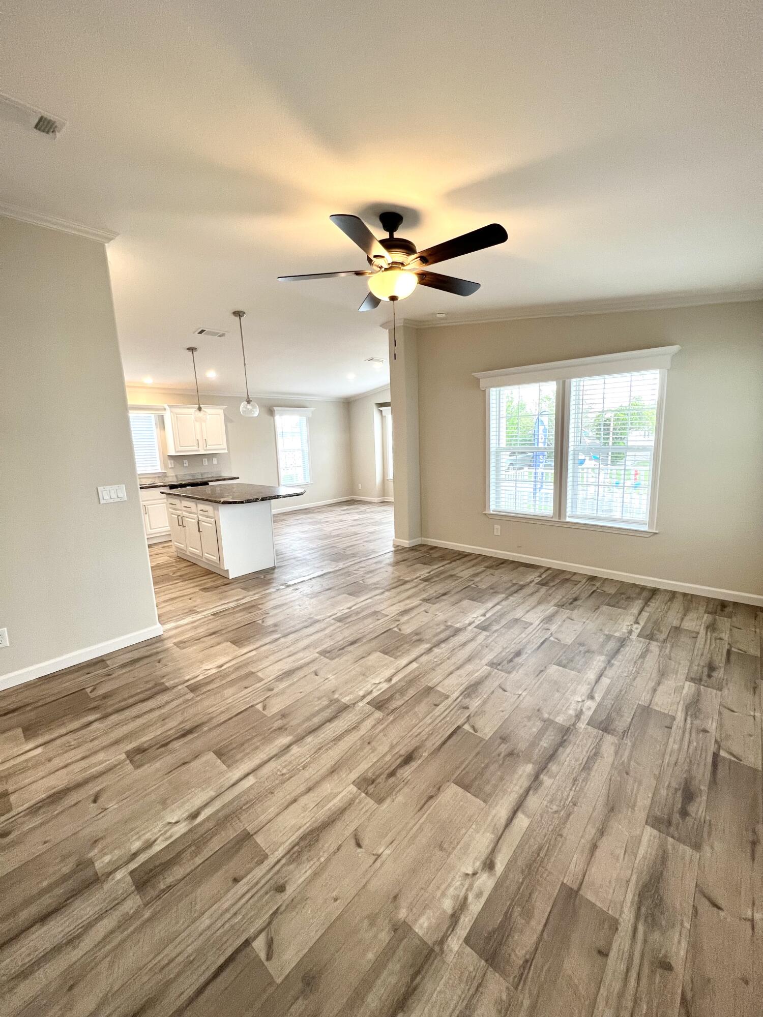 4099 74th Road North, Unit 409 West Palm Beach, FL 33404 - Photo 4 of 18 an empty room with wooden floor fan and windows