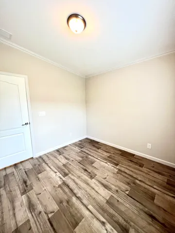 a view of a room with wooden floor and white walls