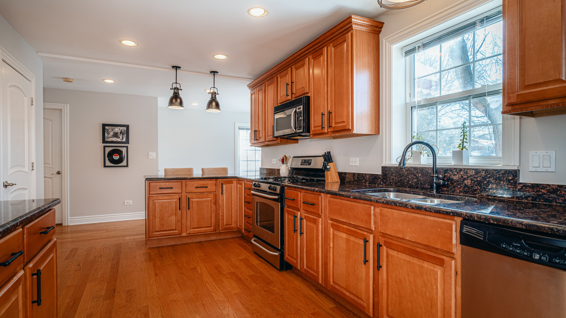 241 Devon Avenue Park Ridge, IL 60068 - Photo 8 of 46 a kitchen with stainless steel appliances granite countertop a stove a sink dishwasher and a microwave oven with large wooden cabinets