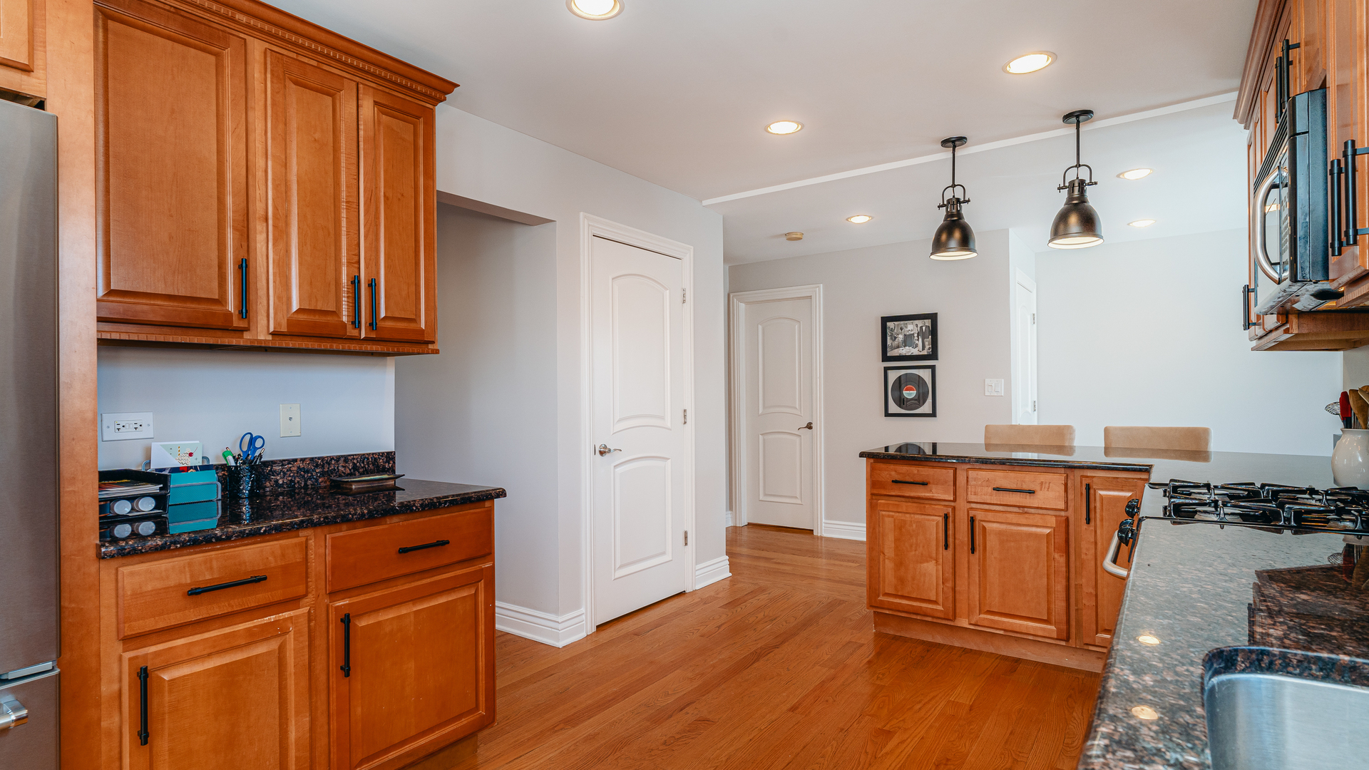 241 Devon Avenue Park Ridge, IL 60068 - Photo 9 of 46 a kitchen with stainless steel appliances granite countertop a refrigerator a sink dishwasher and wooden cabinets with wooden floor
