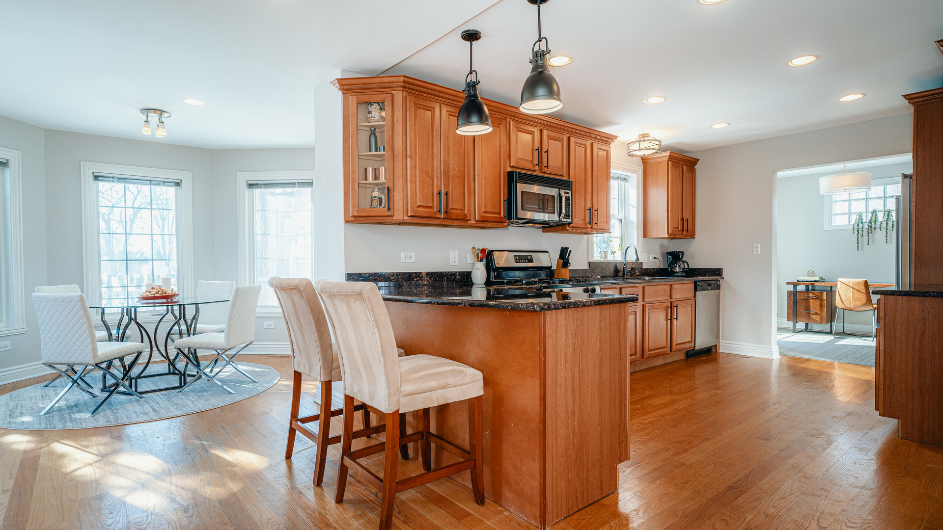 241 Devon Avenue Park Ridge, IL 60068 - Photo 10 of 46 a kitchen with stainless steel appliances granite countertop a stove a sink a microwave a dining table and chairs with wooden floor