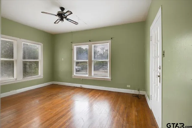 a view of room with window ceiling fan and hardwood floor