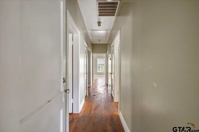 a view of a hallway with wooden floor and staircase