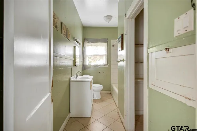 a bathroom with a granite countertop shower a mirror and a toilet