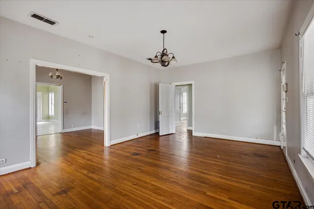 a view of an empty room with wooden floor
