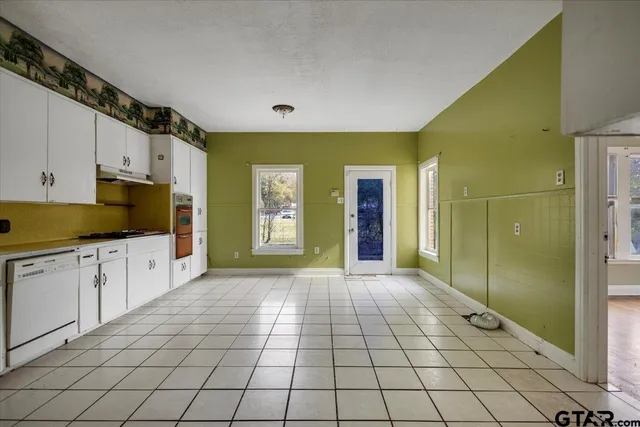 a open kitchen with window and cabinets