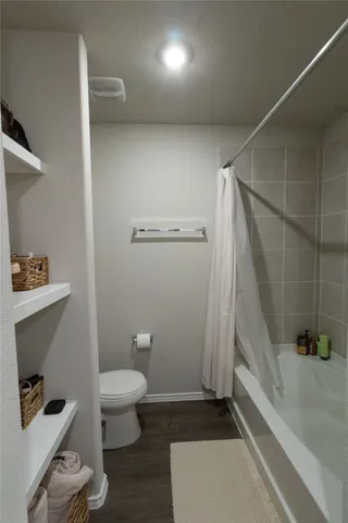 a bathroom with a toilet and a shower