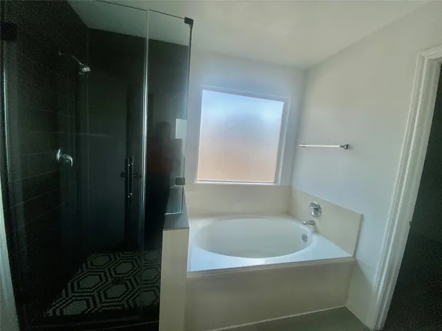 a bathroom with a bathtub and a shower