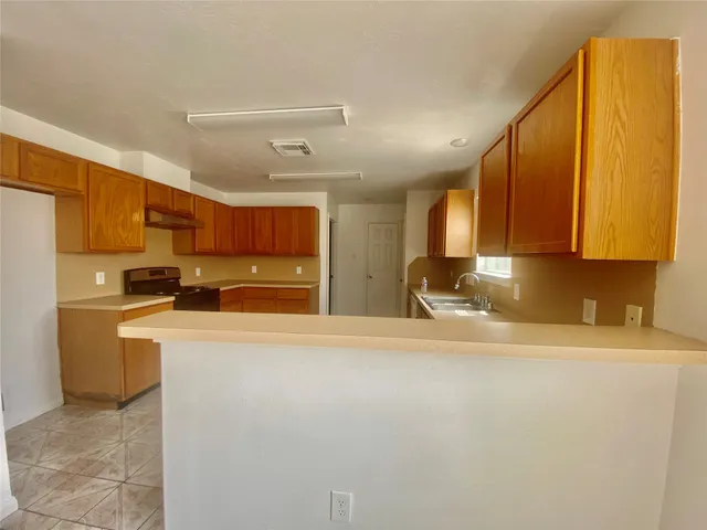 a kitchen with stainless steel appliances granite countertop a refrigerator a stove top oven a sink and dishwasher