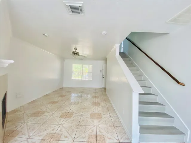 a view of an empty room with stairs and a window