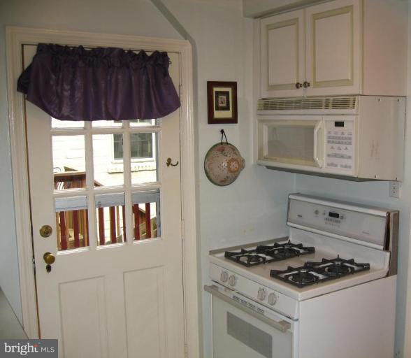 9919 Big Rock Road Silver Spring, MD 20901 - Photo 10 of 23 a kitchen with stainless steel appliances a stove a white cabinet and a microwave