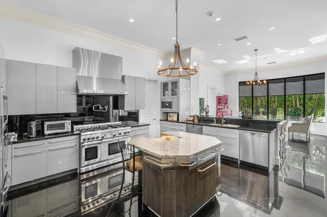 a kitchen with stainless steel appliances granite countertop a sink a stove and a refrigerator