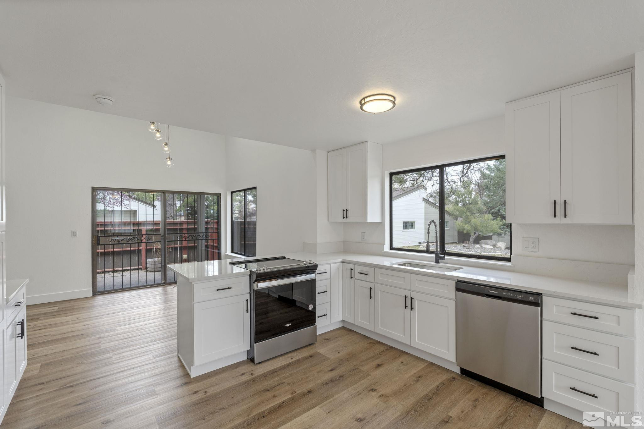 445 Anne Marie Court Reno, NV 89509 - Photo 17 of 27 a kitchen with granite countertop a stove a sink and wooden floors