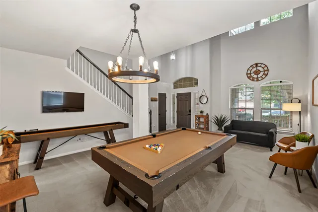 a living room with a table chairs and a chandelier