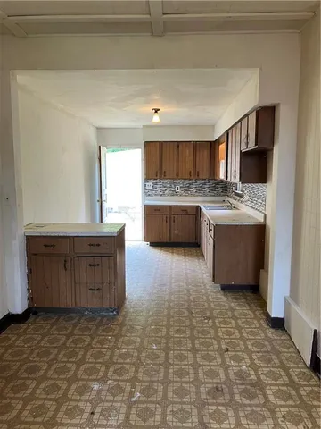 a kitchen with kitchen island granite countertop a stove and a sink
