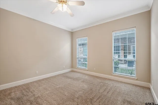 an empty room with windows and fan