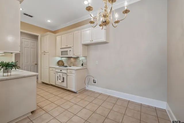 a kitchen with stainless steel appliances a white stove top oven and cabinets