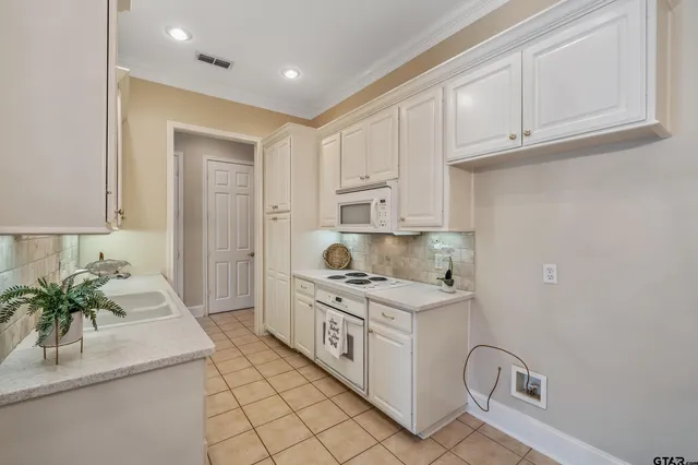 a kitchen with stainless steel appliances granite countertop a sink a stove and a refrigerator