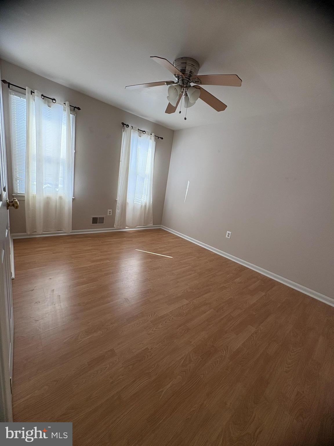 7910 Richfield Road Springfield, VA 22153 - Photo 10 of 14 an empty room with wooden floor fan and windows