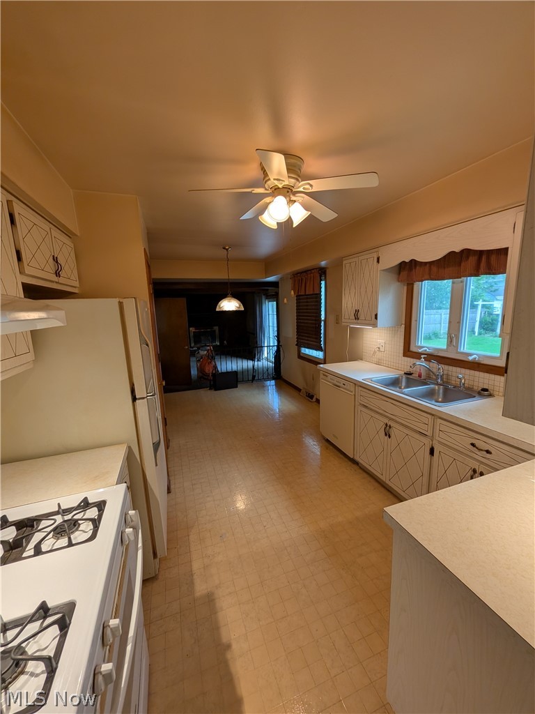 1161 Gulf Road Elyria, OH 44035 - Photo 12 of 34 Spacious kitchen featuring patterned vinyl flooring, white cabinetry with decorative X-panel detailing, laminate countertops, and a double basin sink