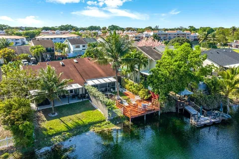 an aerial view of a house with a garden and lake view