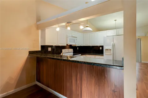 a living room with stainless steel appliances kitchen island granite countertop furniture and a fireplace