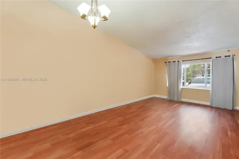 a view of a room with wooden floor and a window