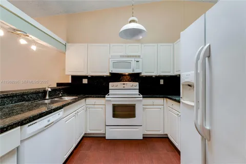 a kitchen with a sink a stove and refrigerator