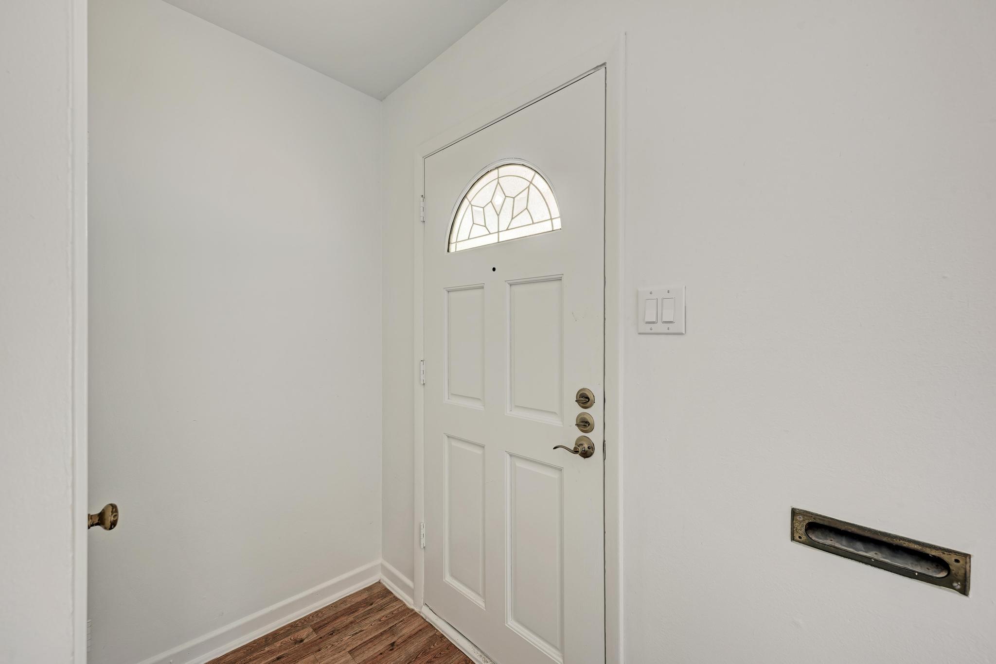 7804 Rutgers Avenue Austin, TX 78757 - Photo 28 of 32 A classic front door with an arched window opens into a crisp entry hallway.
