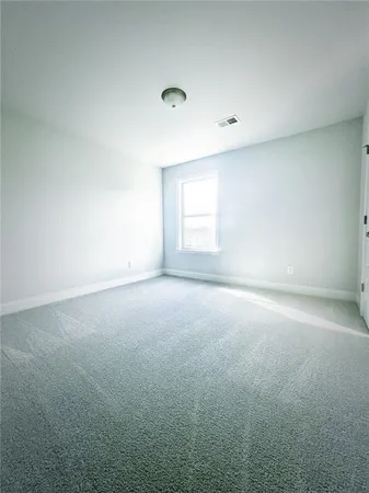 an empty room with a window and a ceiling fan