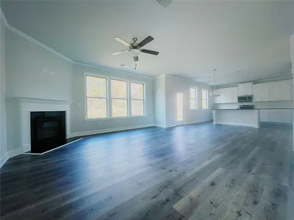 a view of empty room with wooden floor and fireplace