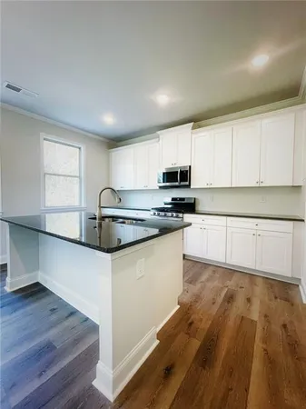 a kitchen with wooden floors and white appliances